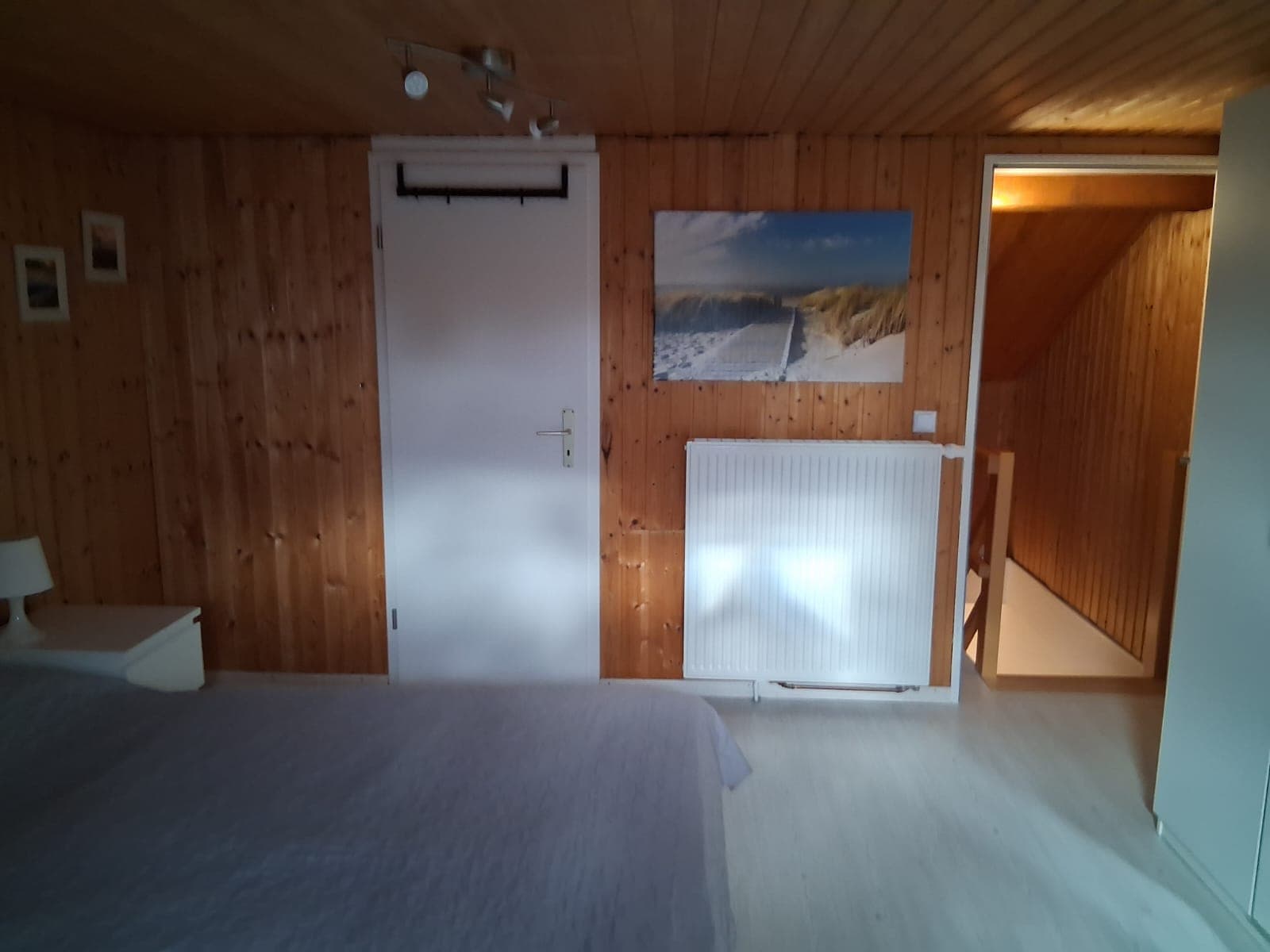 Großes Schlafzimmer mit Blick zur Tür und zum Nebenraum
